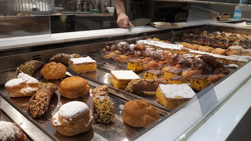 Banco della pasticceria con cannoli, bignè, millefoglie e cassatine